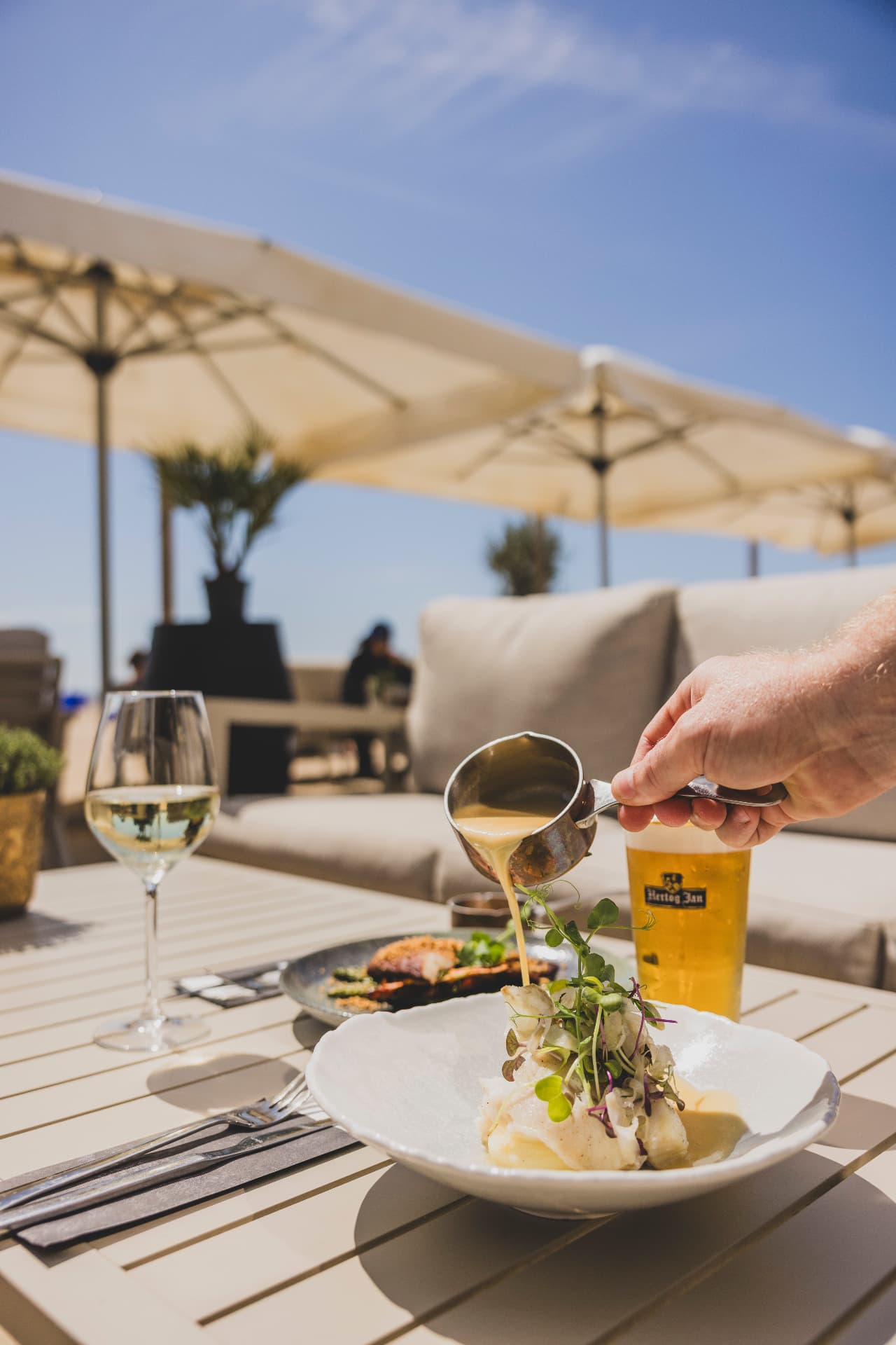 Gerecht wordt afgemaakt aan tafel op het terras aan zee