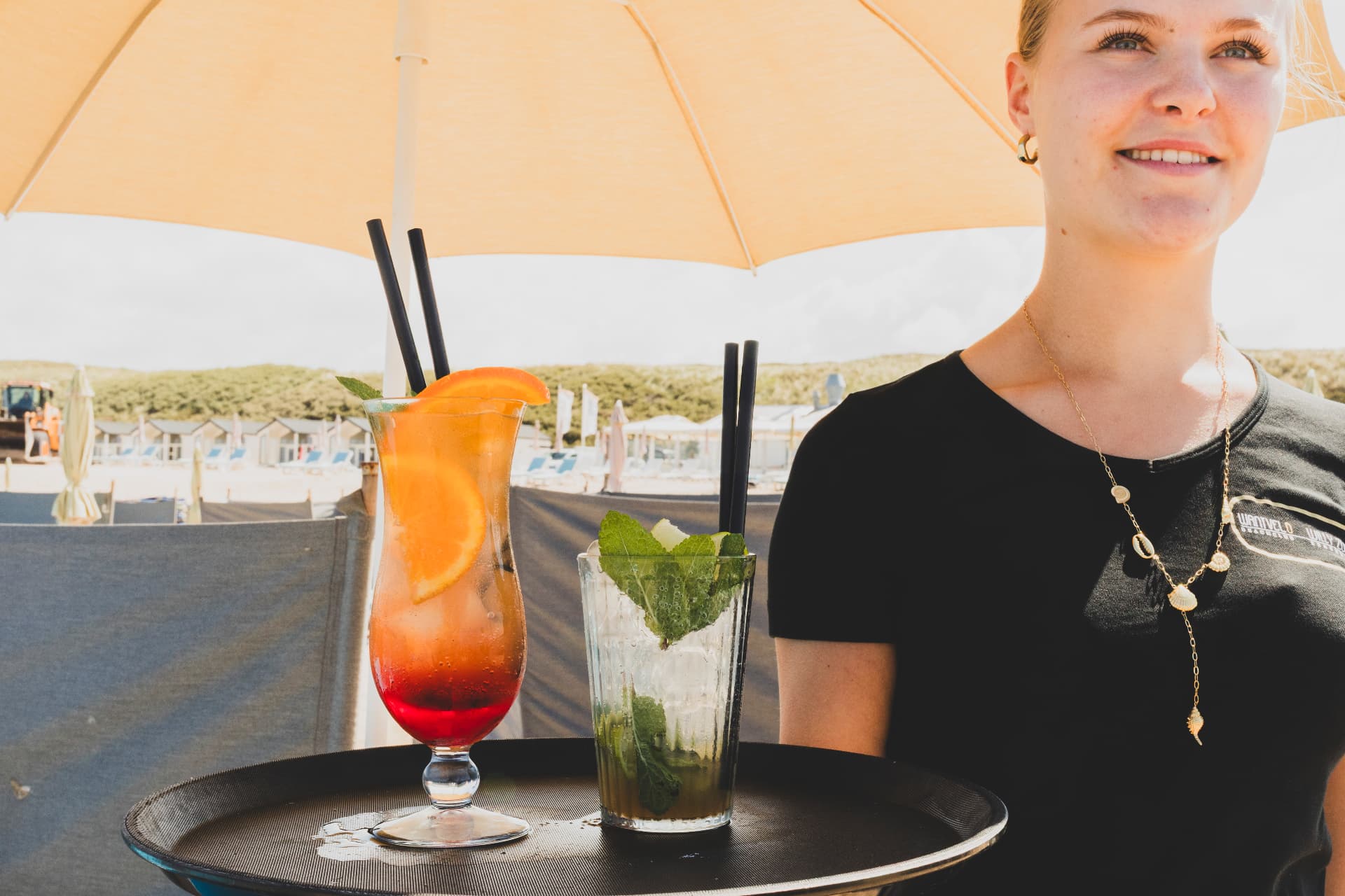 Server met twee verse cocktails op het terras van Wantveld