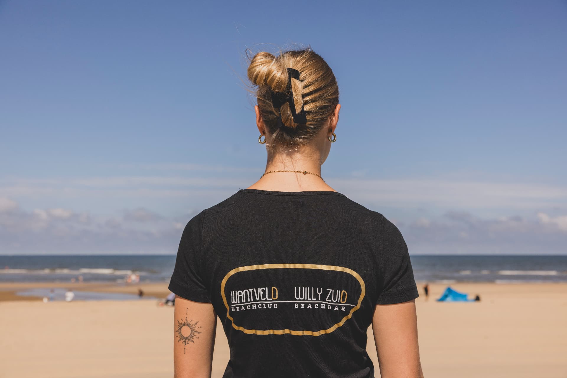 Medewerker van Wantveld op het strand met uitzicht op zee