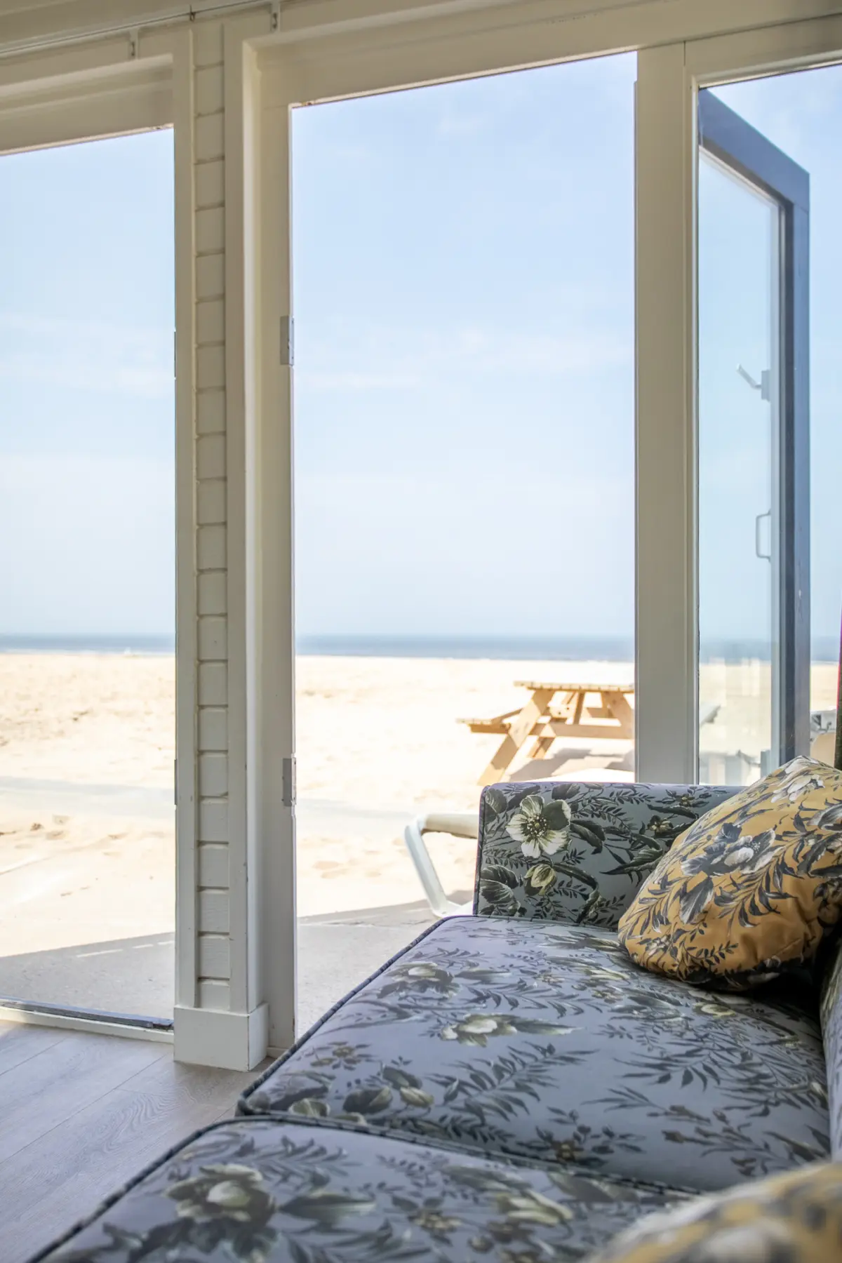Uitzicht vanuit de woonkamer door de openstaande deuren op het strand